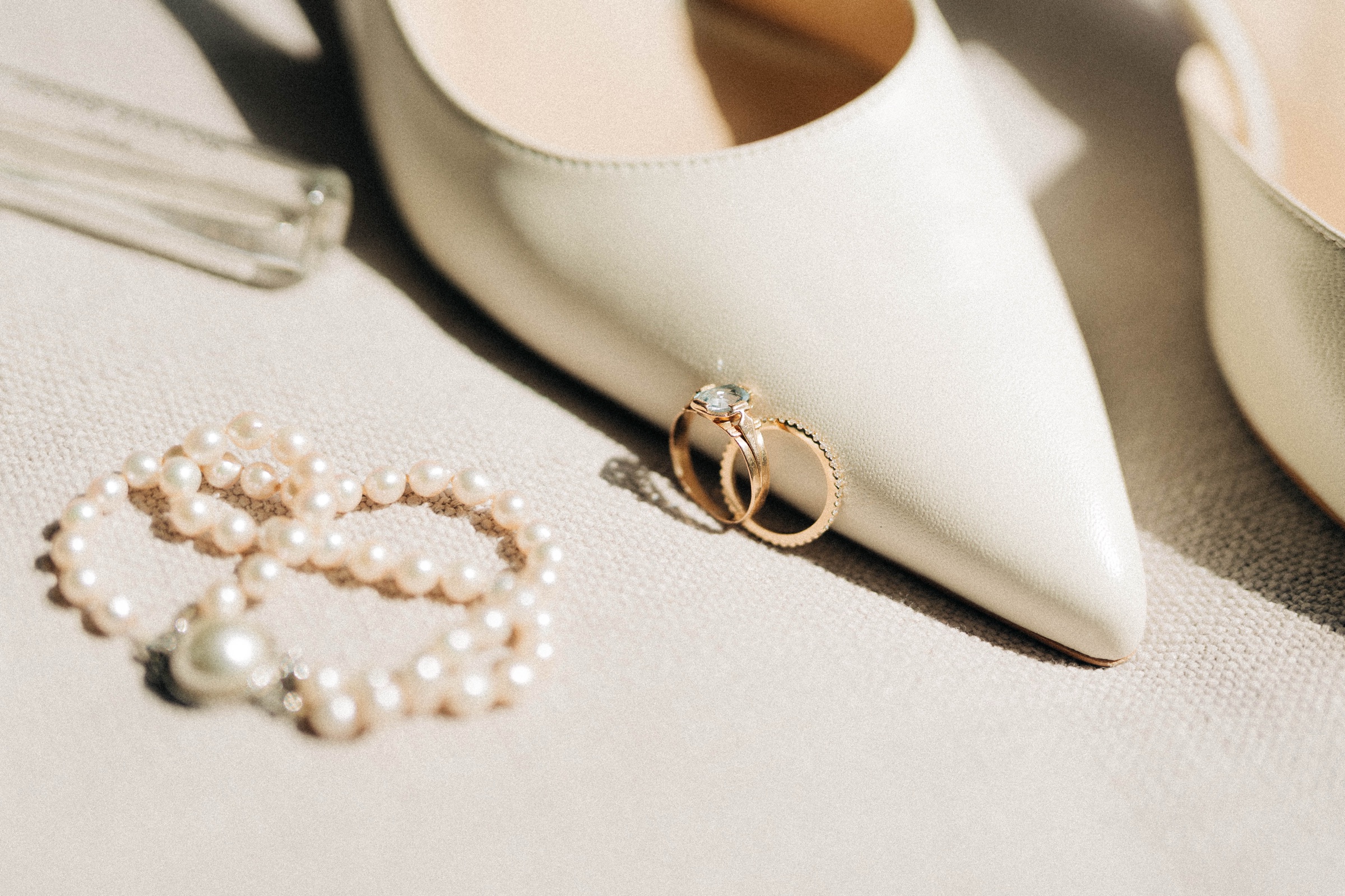 Wedding shoes and rings laid out before a fitting